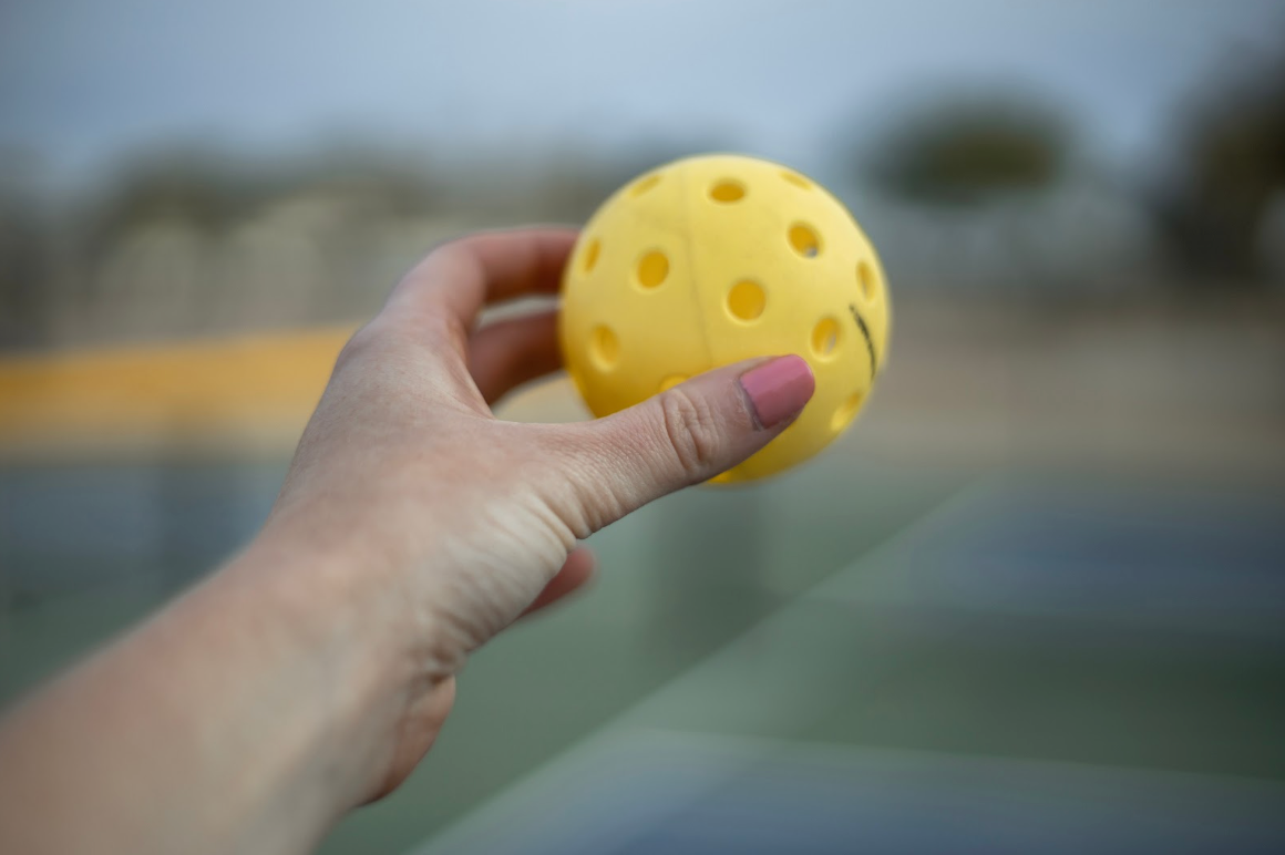 Woman holding a tennis ball in the air