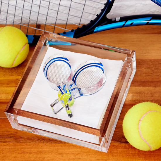 Acrylic cocktail napkin holder featuring tennis racquets weights.