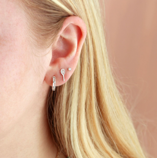 Woman's ear with a tennis racquet earring
