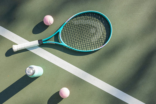 Tennis racquet and balls on tennis court.