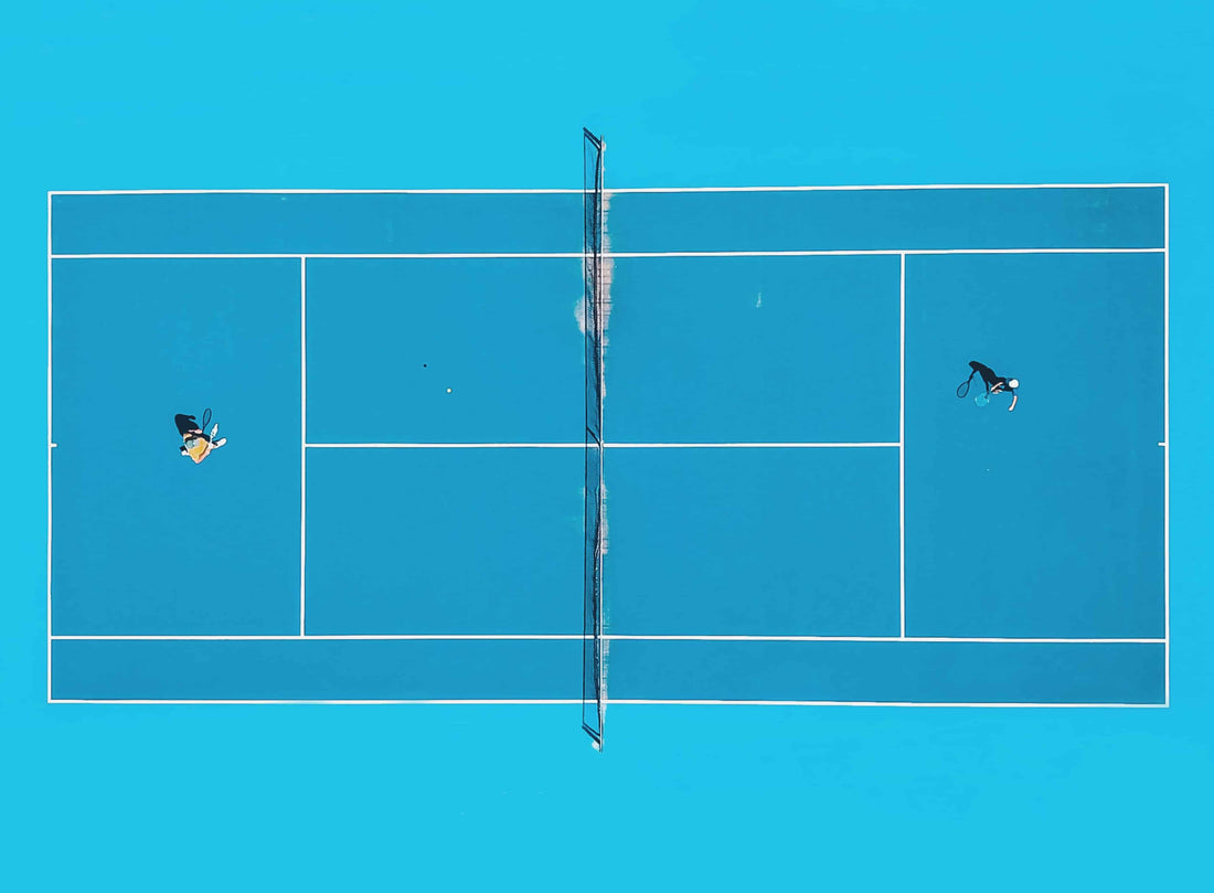 Tennis match on an aqua blue court. 