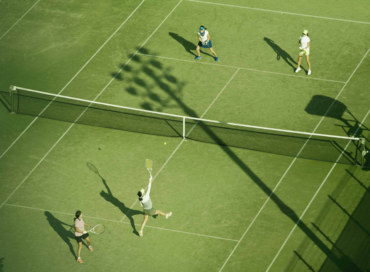 Woman playing tennis on green court