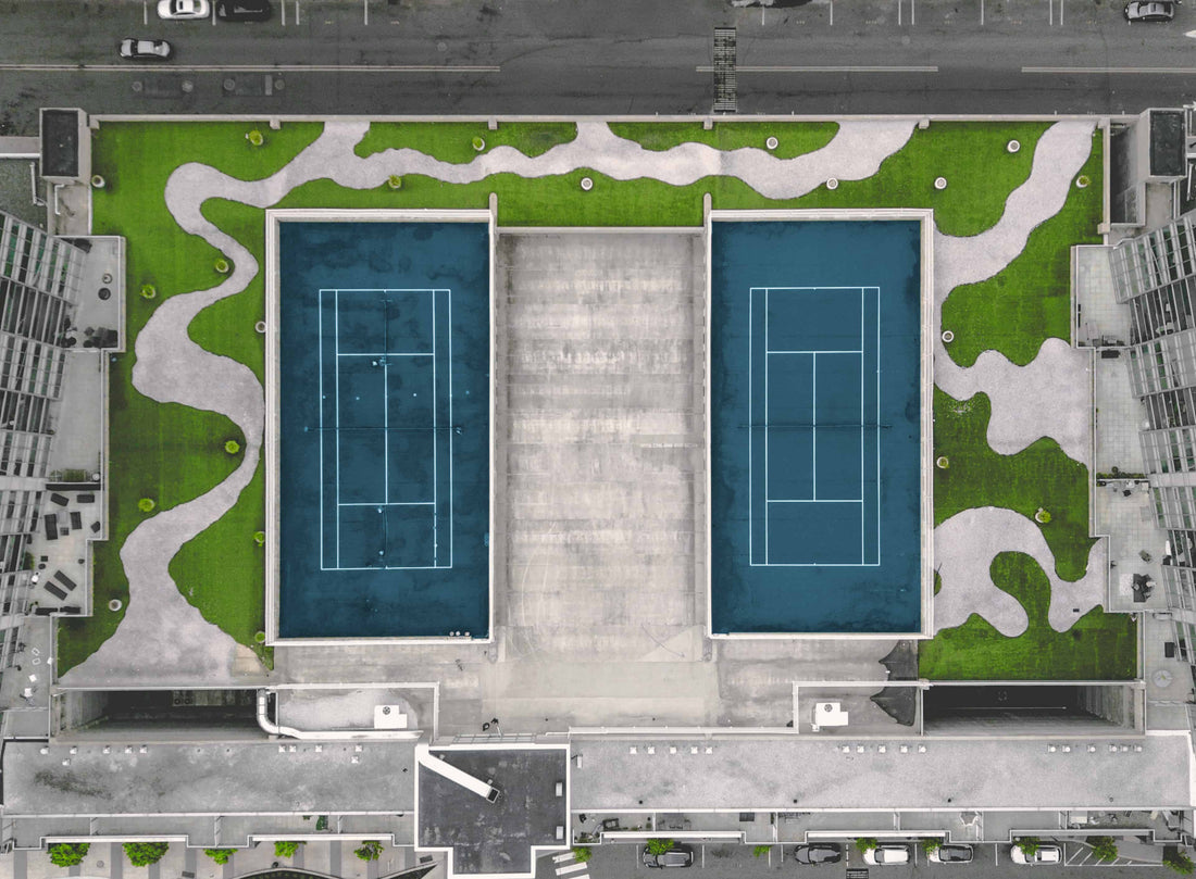 Blue tennis roof court surrounded by grass 