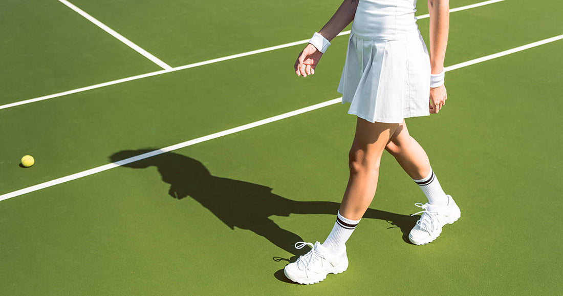 Woman walking on court in tennis whites