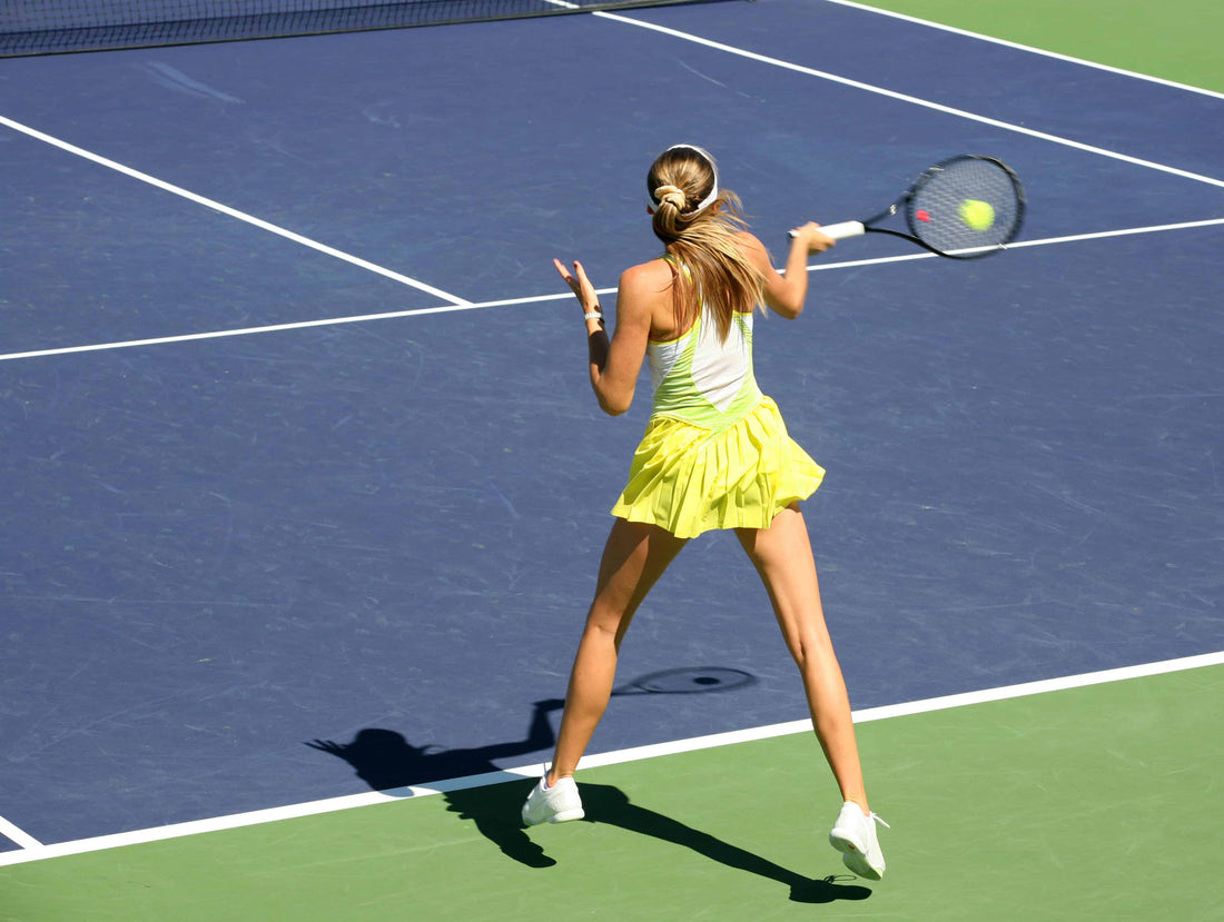 Blonde tennis player hitting a high forehand