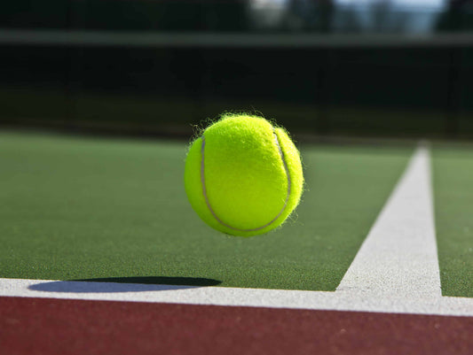 Ball about to bounce on the baseline on a tennis court