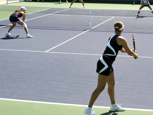 Competitive women's doubles team serving for the win