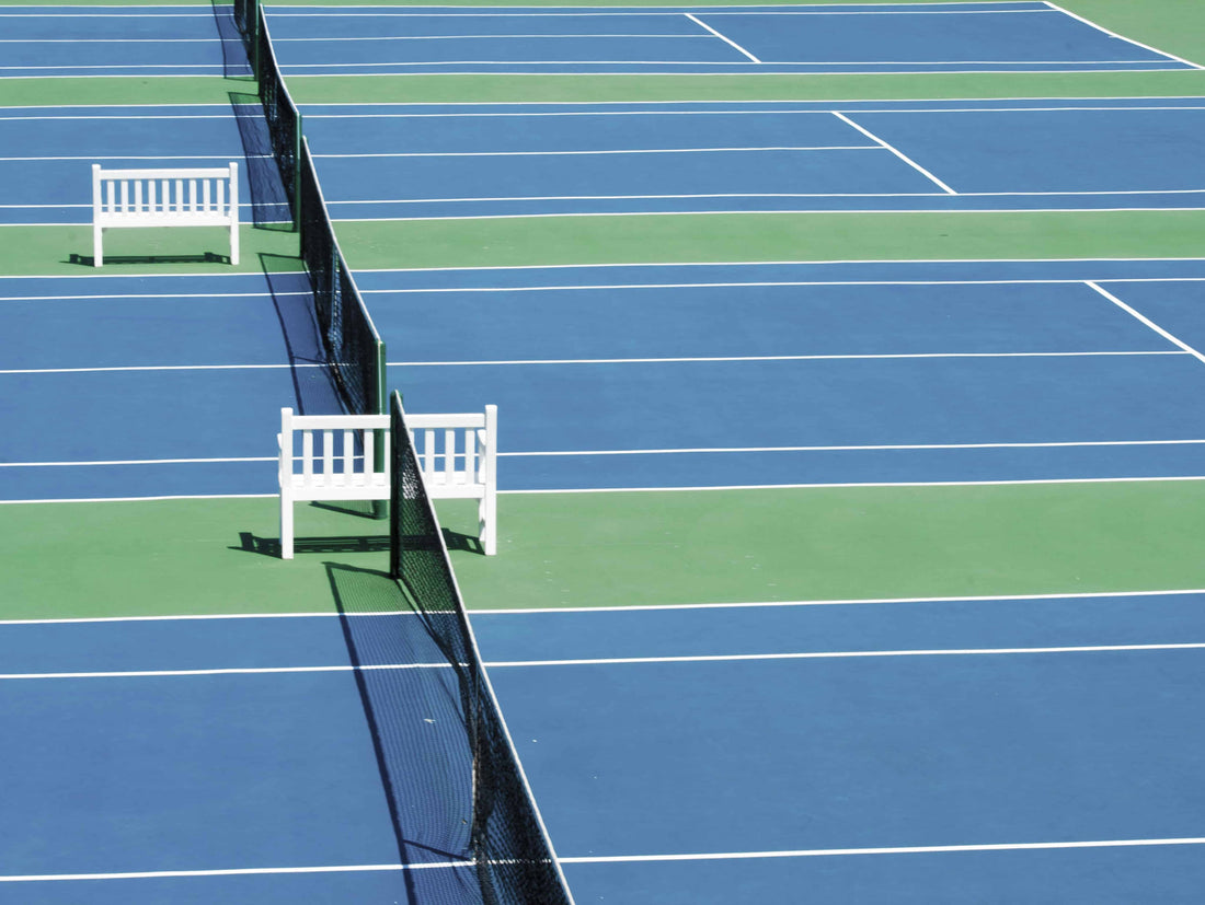 Tennis courts with white benches in between