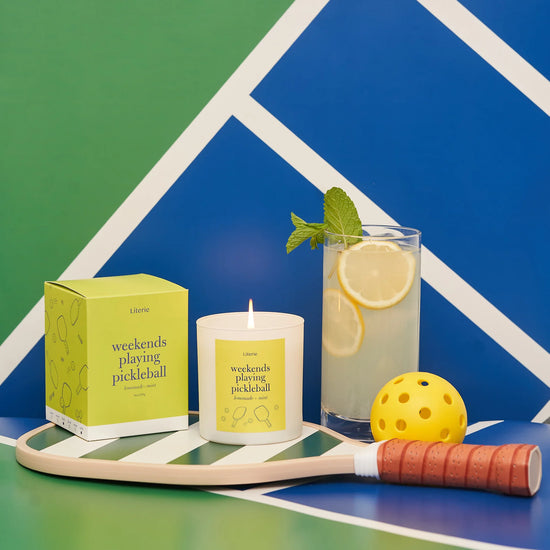 Pickleball themed candle on a pickleball paddle with a lemon and mint drink.