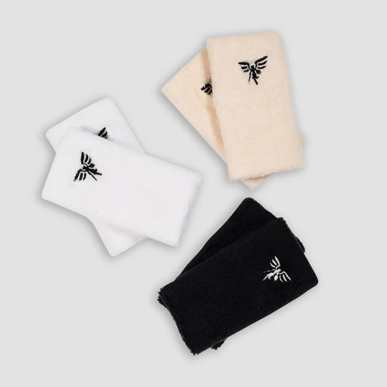 Three pairs of socks in black, white, and beige with an emblem design, arranged on a gray background.