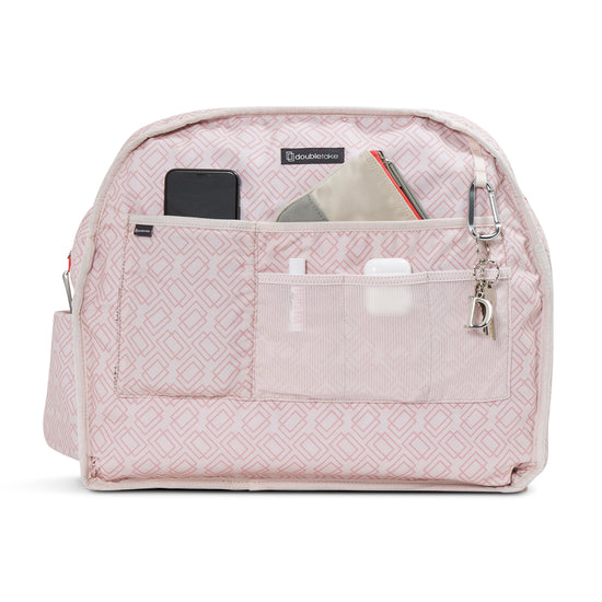 Pink patterned bag organizer with pockets holding a phone, AirPods, and small pouches.