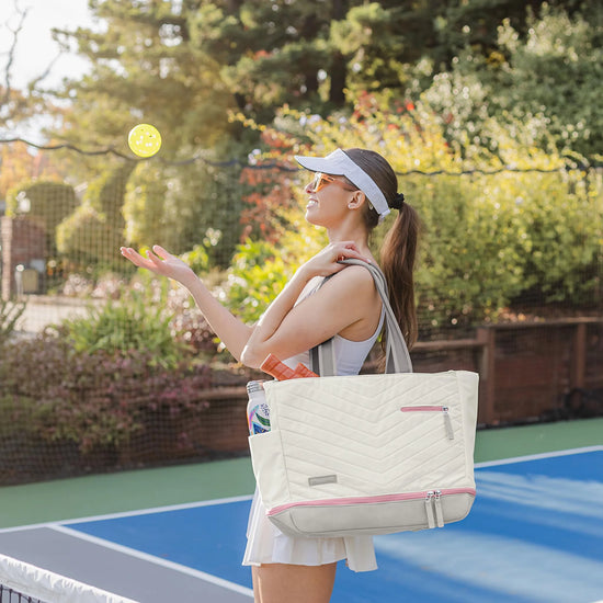 Woman carrying Doubletake Parisii bag while throwing a pickleball.