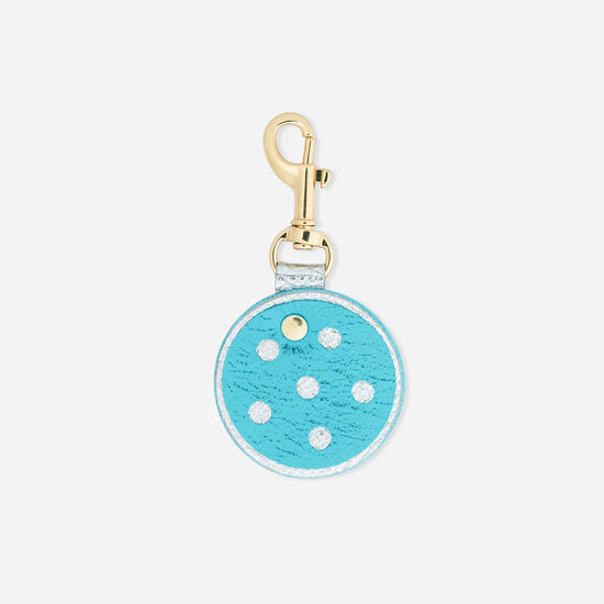 Round blue keychain with white polka dots and a gold clasp on a white background.