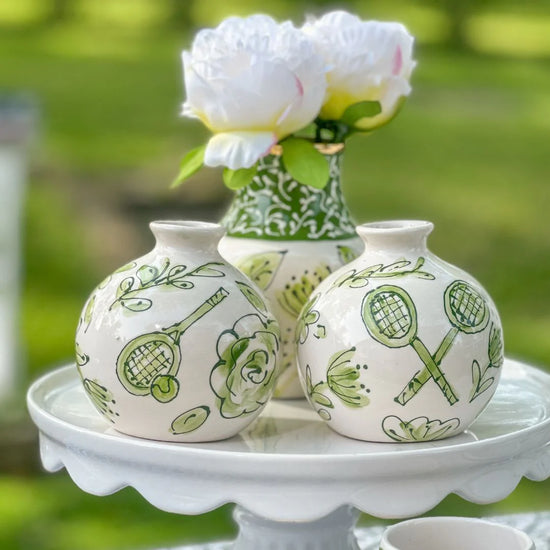 Two small tennis ball vases with painted tennis details.