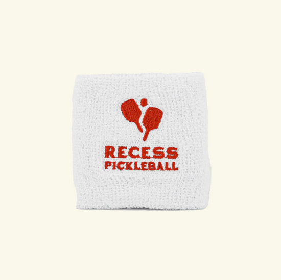 White wristband with red Recess Pickleball logo featuring two paddles and a ball in the center.