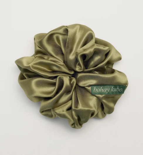A green silk scrunchie with a tag that reads bahay kubo on a white background.