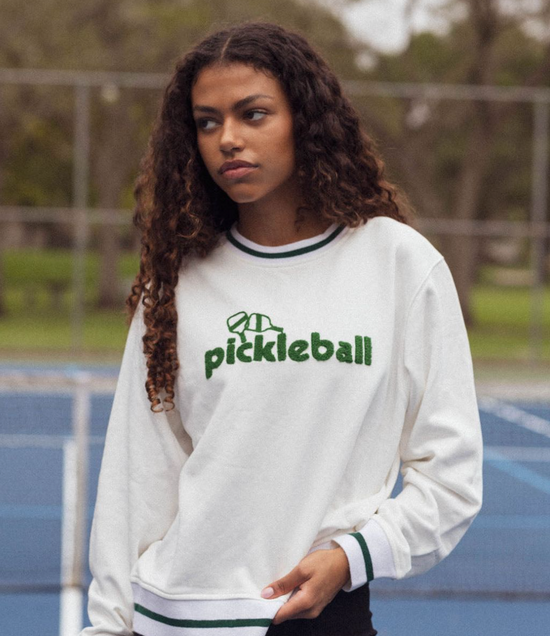 Woman wearing pickleball sweater.