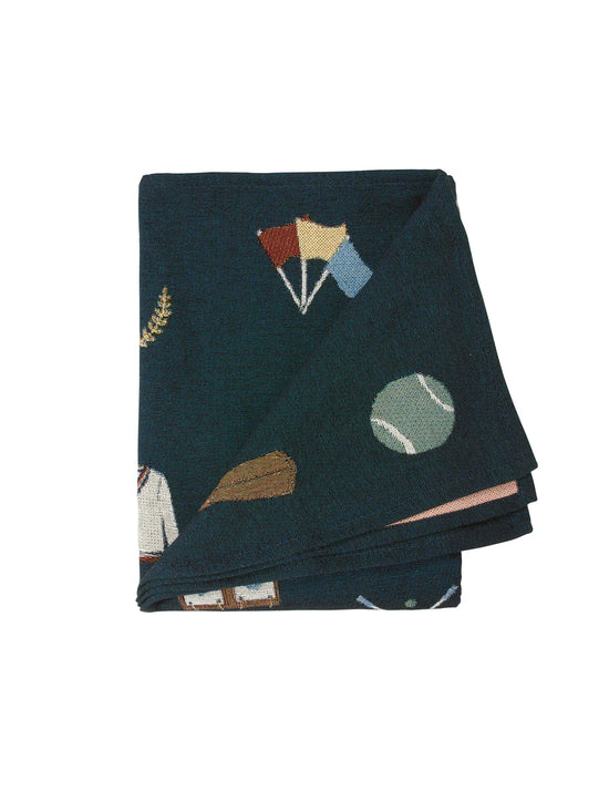 Folded dark green blanket with sports-themed embroidery, including flags, a ball, and a trophy.