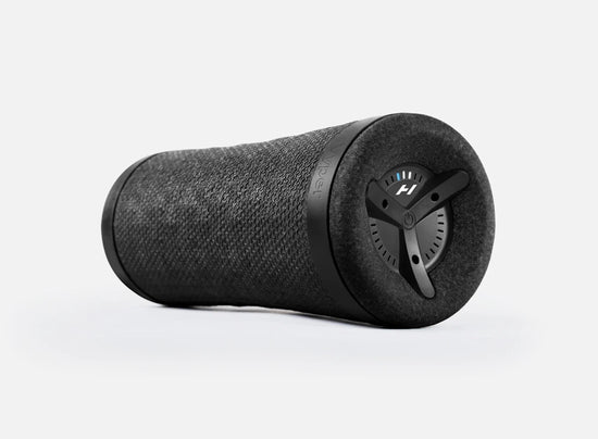 Black cylindrical Bluetooth speaker with a fabric texture and control buttons on one end.