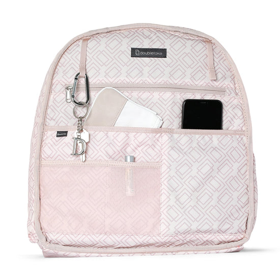 Pink patterned tennis backpack with front pockets, containing a phone, notebook, and a keychain attached to the zip.
