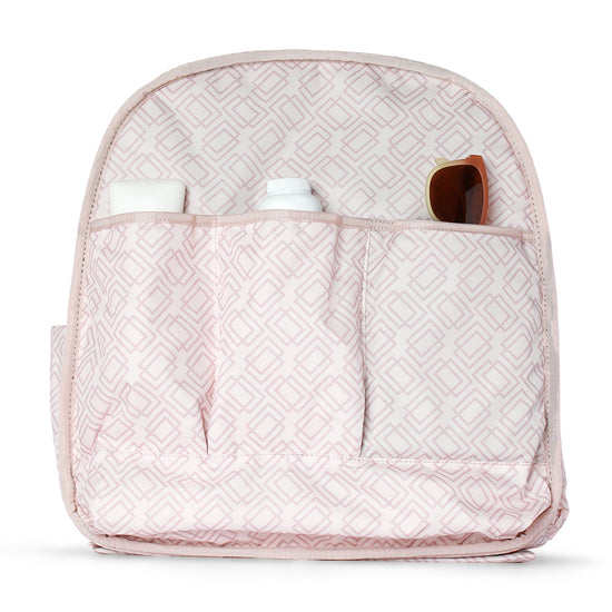 Pink patterned organizer with three pockets holding bottles and sunglasses.