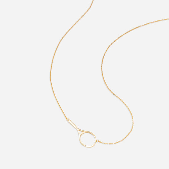 Gold necklace with a delicate chain and a minimalist circular pendant on a white background.
