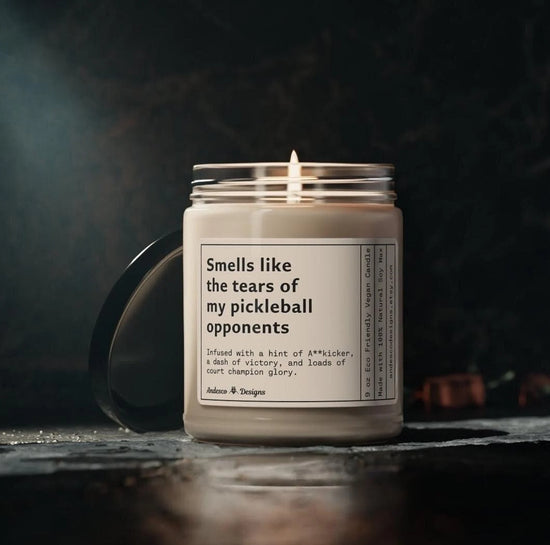 A candle with a humorous label about pickleball opponents and court victory.