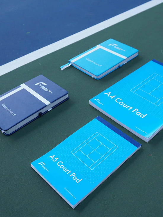 Set of 4 tennis journals on a tennis court.